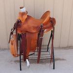 Bronc Buster-mule hide,aluminum oxbows,straight-back,breaststrap,custom deer head carving,floral conchos,barbed wire w Santa Fe border,full basket weave,sm round skirts