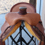 15.5 Trainer full basket weave, latigo wrap, floral conchos, dark straight-back, stirurp leathers on the outside, barbed wire w channels border