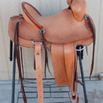 15.5 Trainer full basket weave, latigo wrap, floral conchos, dark straight-back, stirurp leathers on the outside, barbed wire w channels border