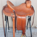 Ultimate Roper 16in, mule hide wrap, floral cochos, basket weave border tooling, stirrup leathers on the outside. Comes with choice of rawhide stirrups