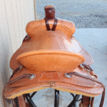 Ultimate Roper 16in, mule hide wrap, floral cochos, basket weave border tooling, stirrup leathers on the outside. Comes with choice of rawhide stirrups