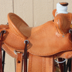 Bronc Buster - 16 in, mule hide, straight-back, full bskt wv, strp lthrs out and tooled, floral conchos, all light leather, Diamond w sswirl border - $2870