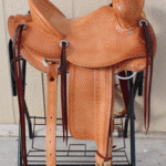 Bronc Buster - 16 in, mule hide, straight-back, full bskt wv, strp lthrs out and tooled, floral conchos, all light leather, Diamond w sswirl border - $2870