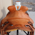 Bronc Buster - 16 in, mule hide, straight-back, full bskt wv, strp lthrs out and tooled, floral conchos, all light leather, Diamond w sswirl border - $2870