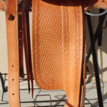 Bronc Buster - 16 in, mule hide, straight-back, full bskt wv, strp lthrs out and tooled, floral conchos, all light leather, Diamond w sswirl border - $2870