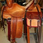 Rancher -2 strand barbed wire w channels, corner basket wv, saddlebags, brass oxbows, stirrup leathers out and tooled, dark straight-back, latigo