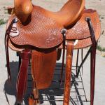 Trainer - full basket weave, Santa Fe Diamond w Barbed Wire border, floral conchos, straight-back cantle, latigo wrap, stirrup leathers out and tooled, brass oxbows